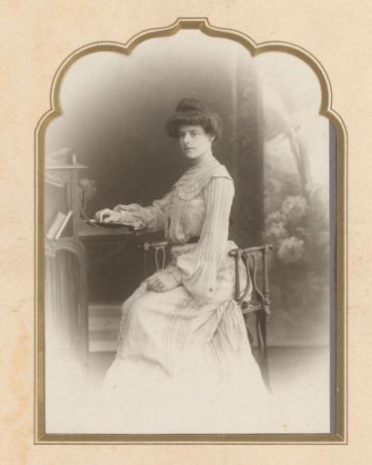 Portrait of a young seated woman with a book