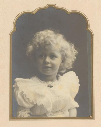 Portrait of a girl with curls in a white dress