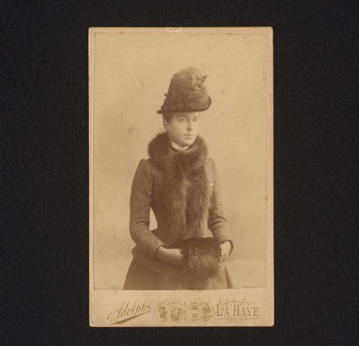 Portrait of a standing woman with a fur shawl and hat