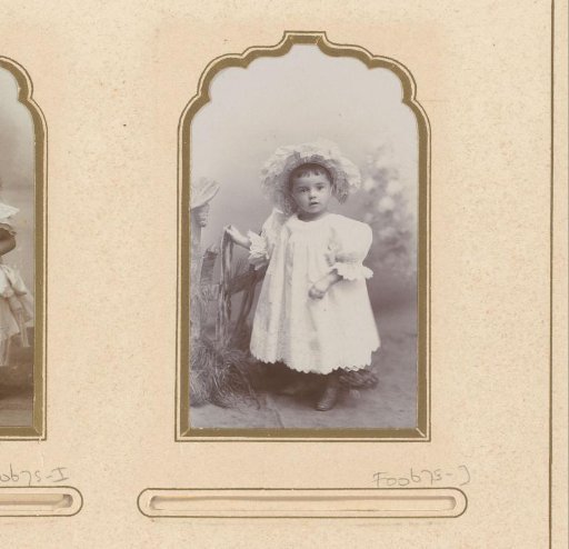 Portrait of a standing girl in a white dress with a hat