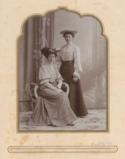 Portrait of two women with hats, against a backdrop
