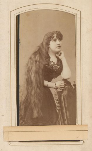 Portrait of a woman leaning on a chair with very long hair