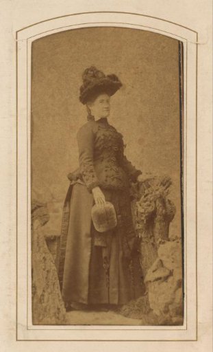 Portrait of a standing woman with a hat and muff
