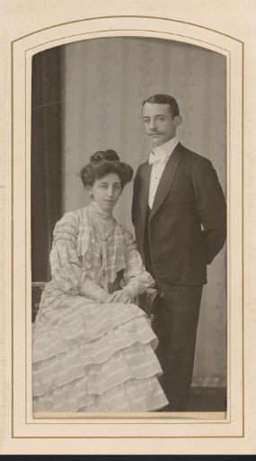 Portrait of a seated woman in a striped gown and a standing man with a moustache