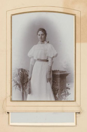 Portrait of a woman with a fan in her hand, by a pedestal