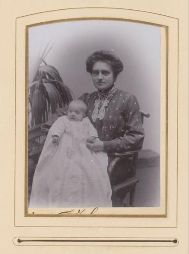 Portrait of a Woman with a Baby in a Christening Gown on Her Lap