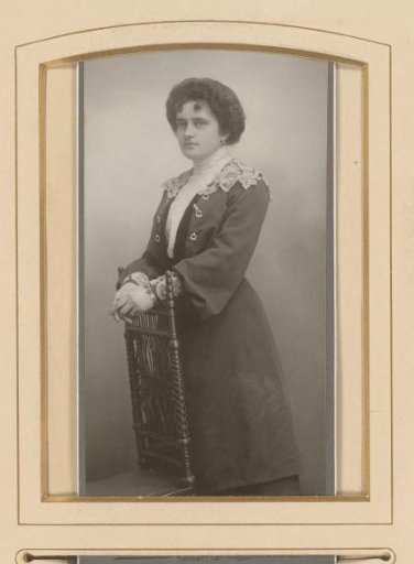 Portrait of a standing woman by a chair