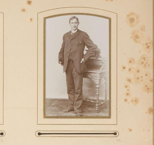 Portrait of a standing man with a hat under his arm