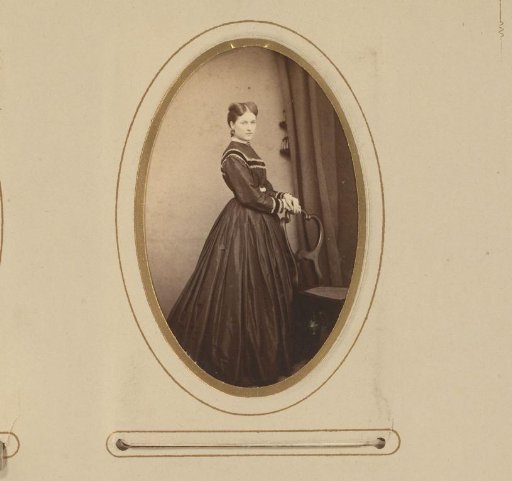 Portrait of a woman standing by a chair