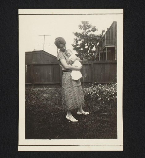 Portrait of a woman with a baby, standing in a garden