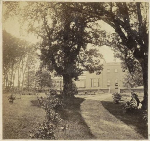 Country house with a park in England, with a woman in the foreground