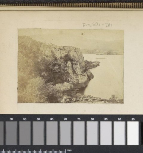 View of a rocky coast by a lake or sea, probably in England