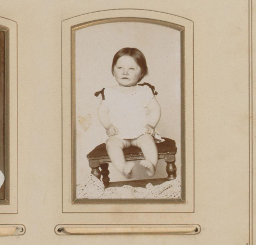Portrait of a baby seated on a footstool