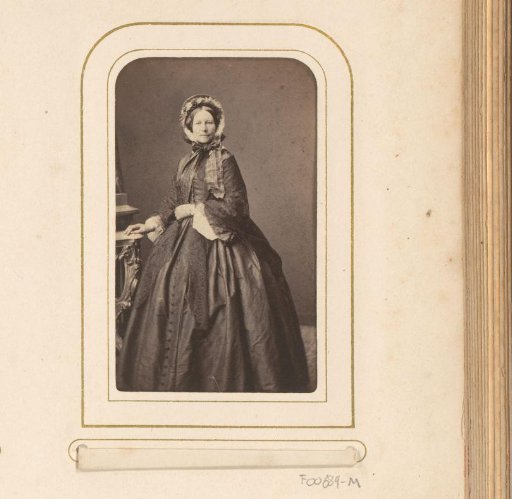 Portrait of a standing woman in a dress with a headdress