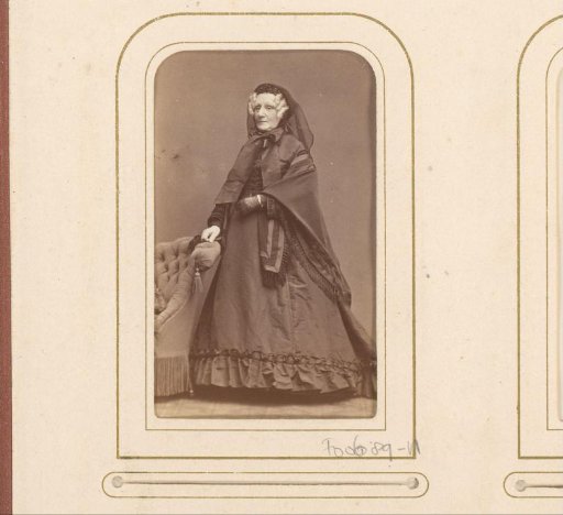 Portrait of a standing woman with shawl and veiled cap