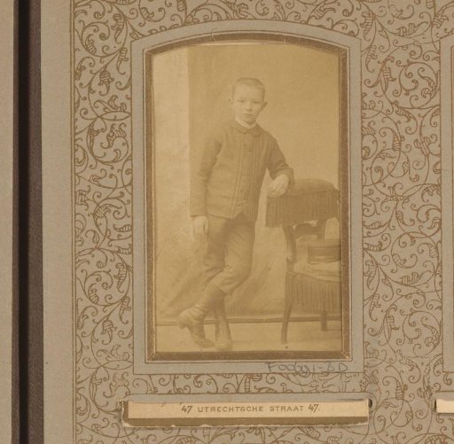 Portrait of a boy by a chair