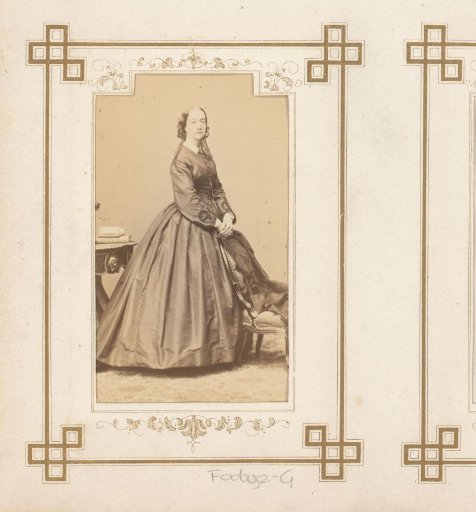 Portrait of a standing woman by a chair