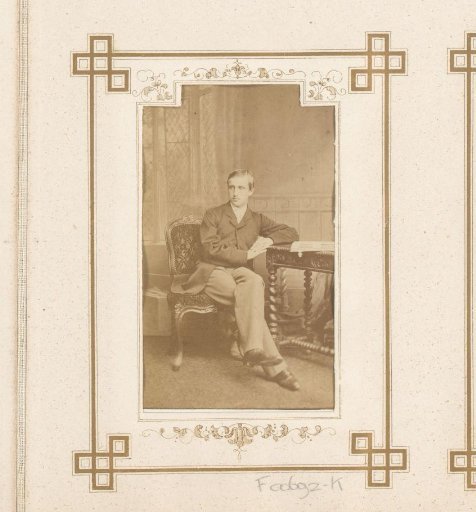 Portrait of a seated man with a photo album