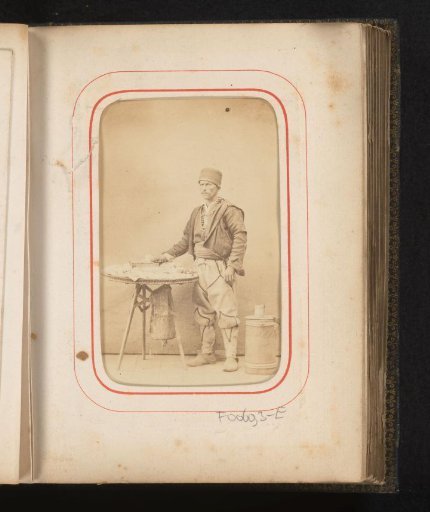 Portrait of a man in Romanian traditional dress at a table
