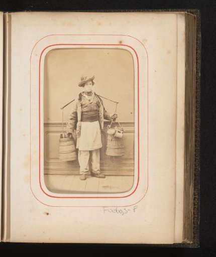 Portrait of a boy in Romanian traditional dress with a yoke and wooden buckets