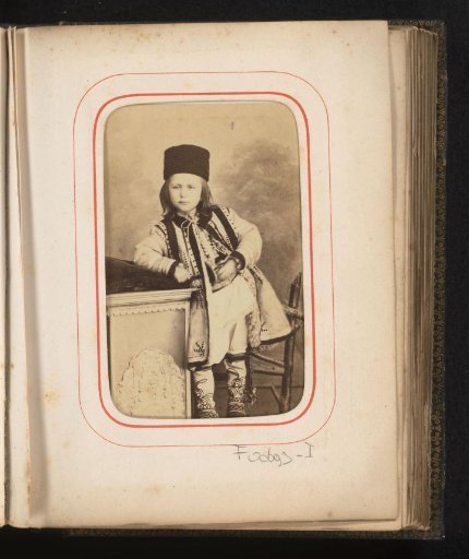 Portrait of a boy in Romanian traditional dress, standing on a chair