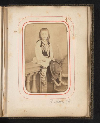 Portrait of a seated child in Romanian costume with hat