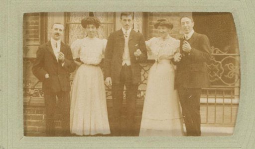 Group portrait of men and women in front of a house