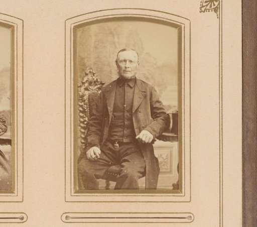 Portrait of a seated man with sideburns