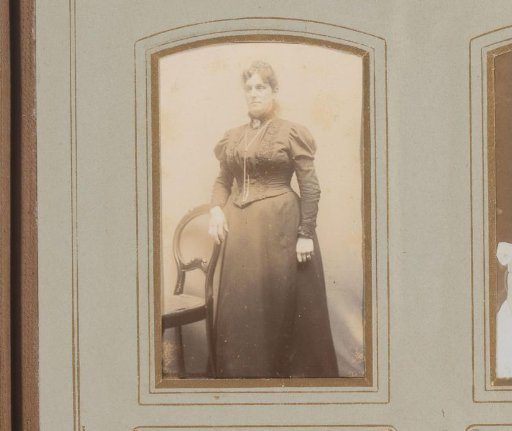 Portrait of a woman standing by a chair