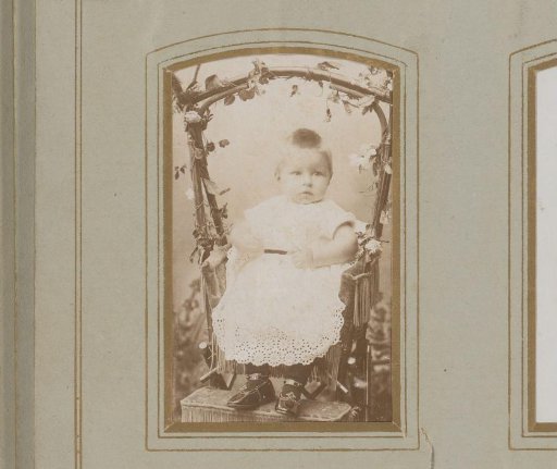 Portrait of a baby, seated on a wicker chair