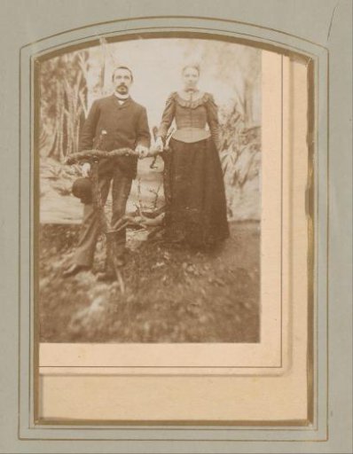 Portrait of a man and woman by a hedge of twigs