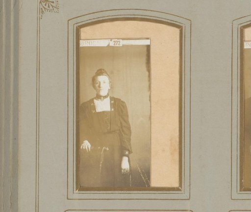 Portrait of a young woman standing by a chair