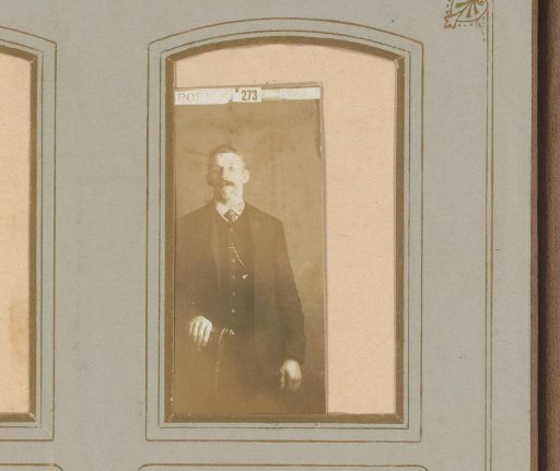 Portrait of a man standing by a chair