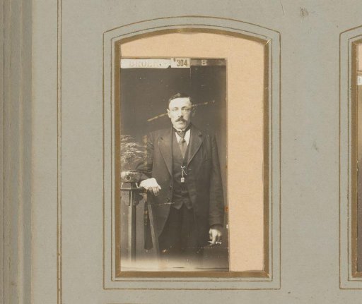 Portrait of a man standing by a table with a plant on it