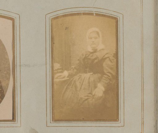 Portrait of a woman with a cap, seated at a table
