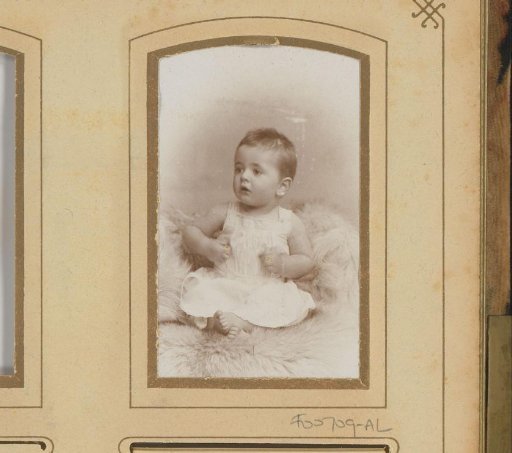 Portrait of a seated baby in a white dress