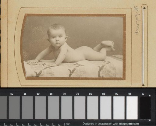 Portrait of a naked baby, lying on a rug