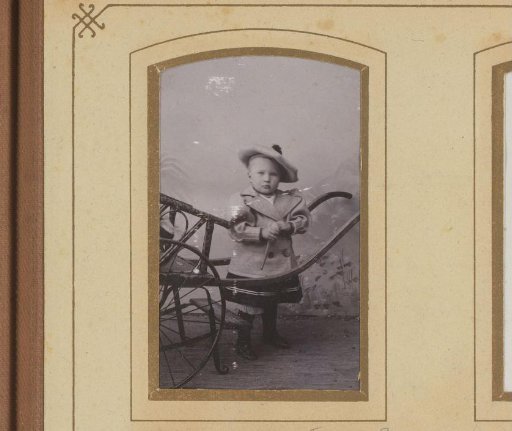 Portrait of a child with a cap beside a cart
