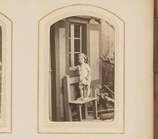 Child standing on a bench in front of a house
