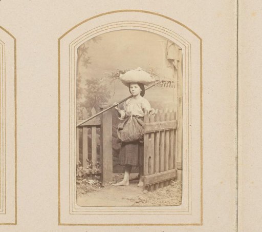 Girl with a rake and branches carried on her head
