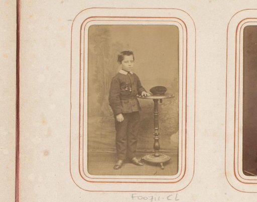 Portrait of a boy by a table with a cap