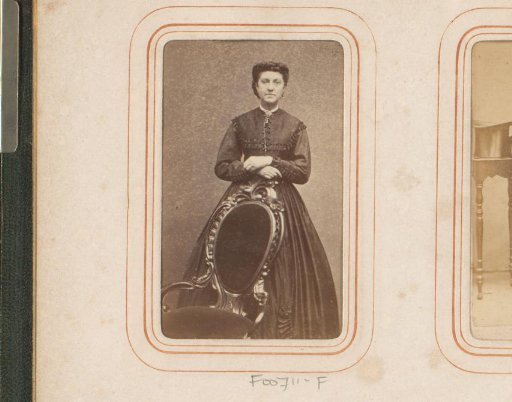Portrait of a standing woman beside a chair