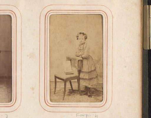 Portrait of a girl beside a chair with an open book
