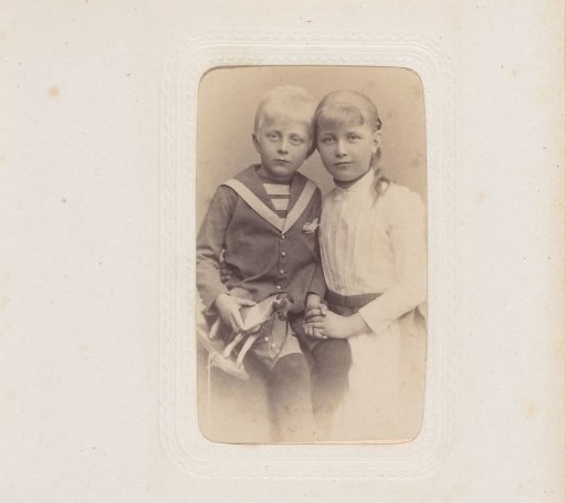Portrait of a girl and a boy with a toy horse in hand