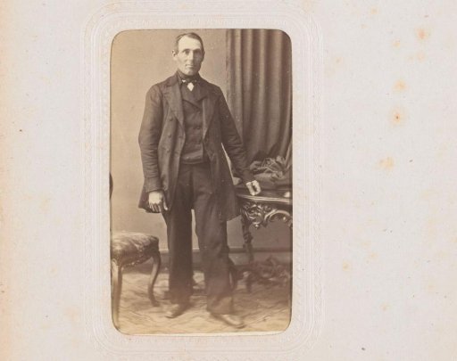 Portrait of a man, standing by a table