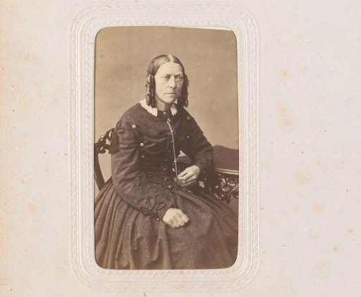 Portrait of a woman, seated at a table