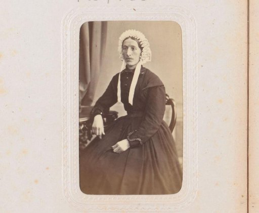Portrait of a woman with a cap, seated at a table