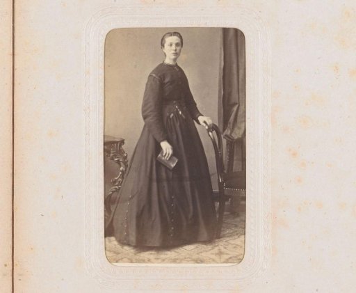 Portrait of a woman with a book in hand, standing by a chair