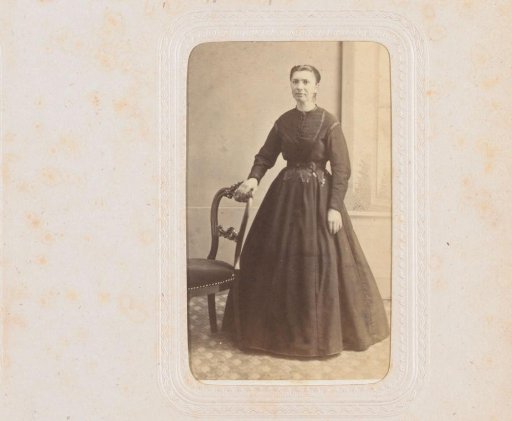 Portrait of a woman, standing by a chair