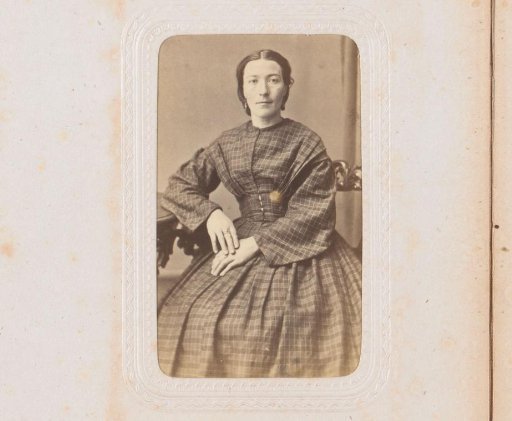 Portrait of a woman, seated at a table
